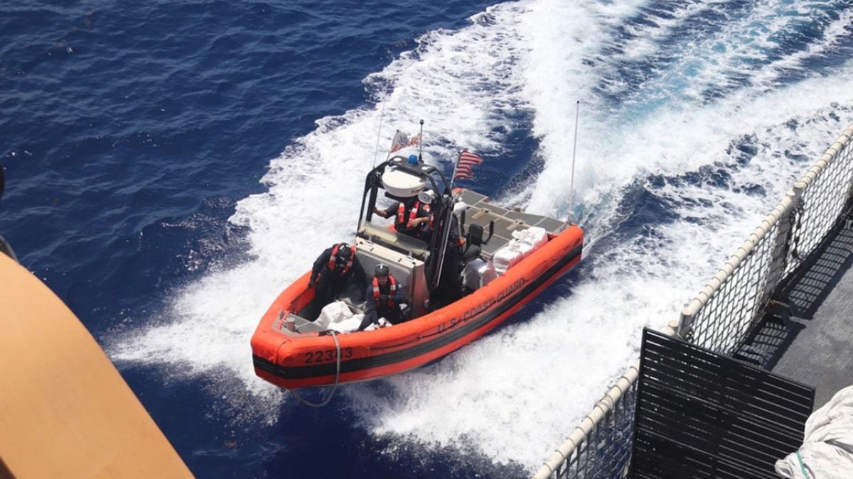 Un bateau de la Garde côtière transportant des drogues illégales à proximité d’un grand navire.