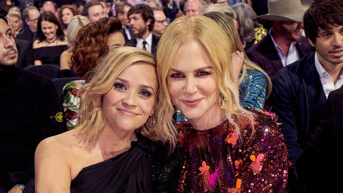 Reese Witherspoon sourit assise à côté de Nicole Kidman lors de la cérémonie de remise des prix