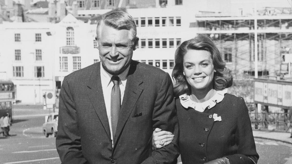 Dyan Cannon et son mari d'alors, Cary Grant, marchant ensemble bras dessus bras dessous en souriant.