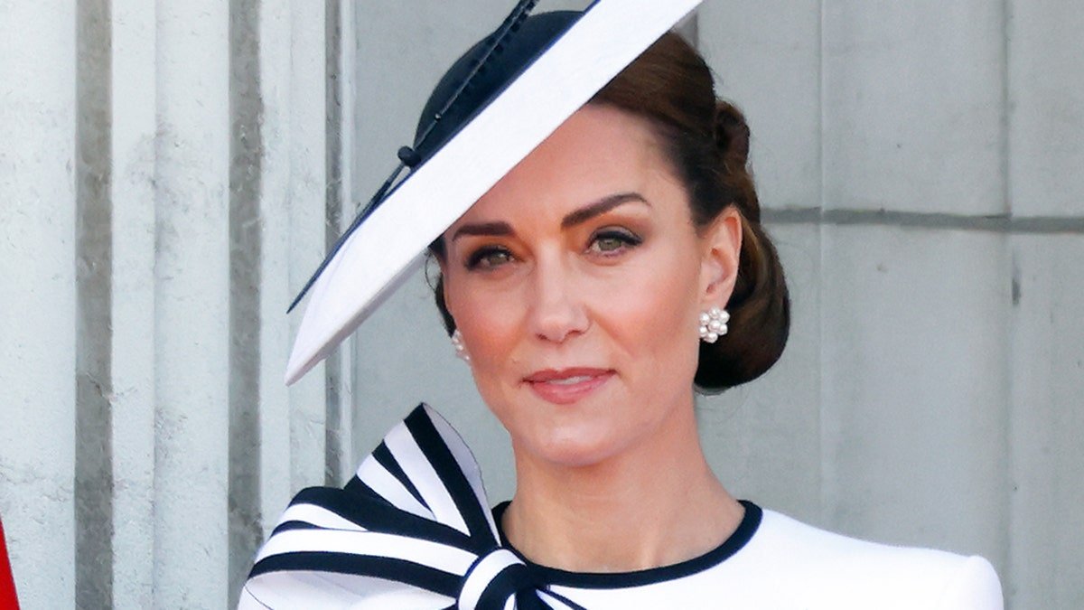 Kate Middleton dans une robe blanche et bleu marine et un chapeau assorti