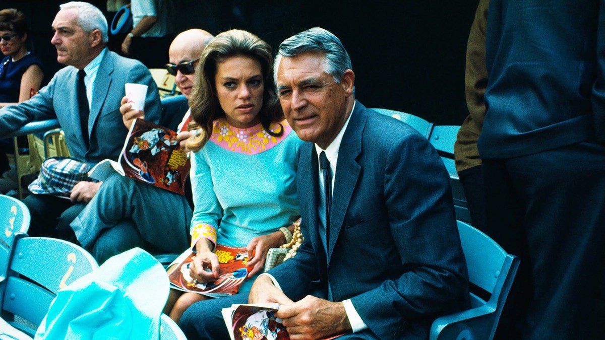 Dyan Cannon et Cary Grant regardent le match avec des expressions sérieuses sur leurs visages.