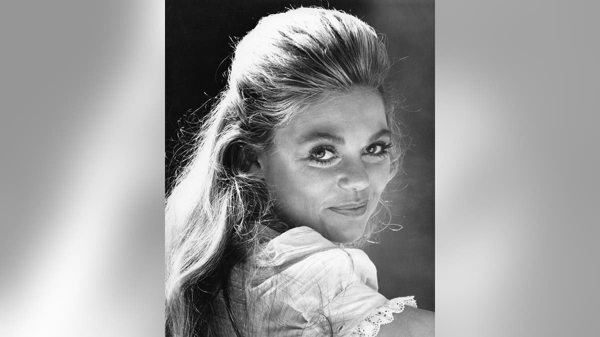 Une jeune Dyan Cannon, la tête tournée et souriante à la caméra.