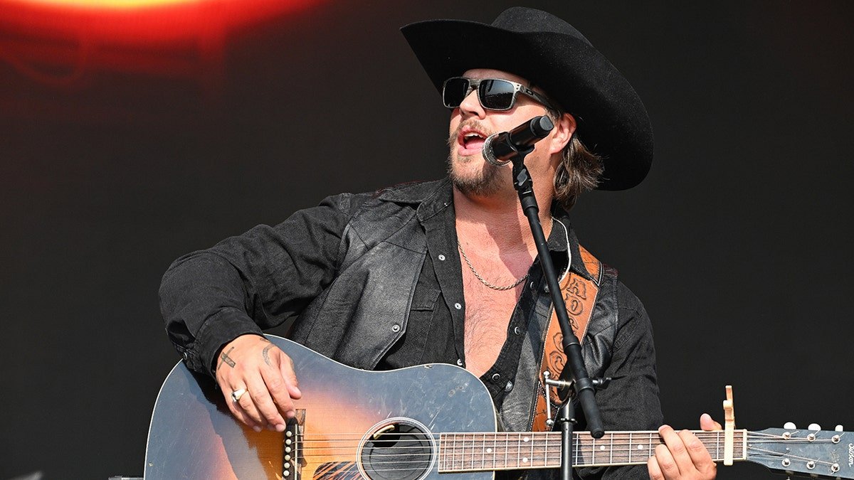 Gavin Adcock se produit sur scène avec un chapeau de cowboy noir au Railbird Music Festival 2025 en juin.