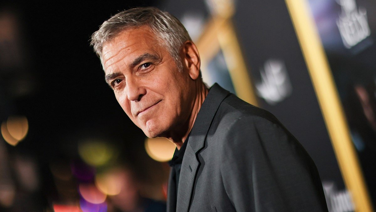 George Clooney porte un costume gris sur le tapis rouge.