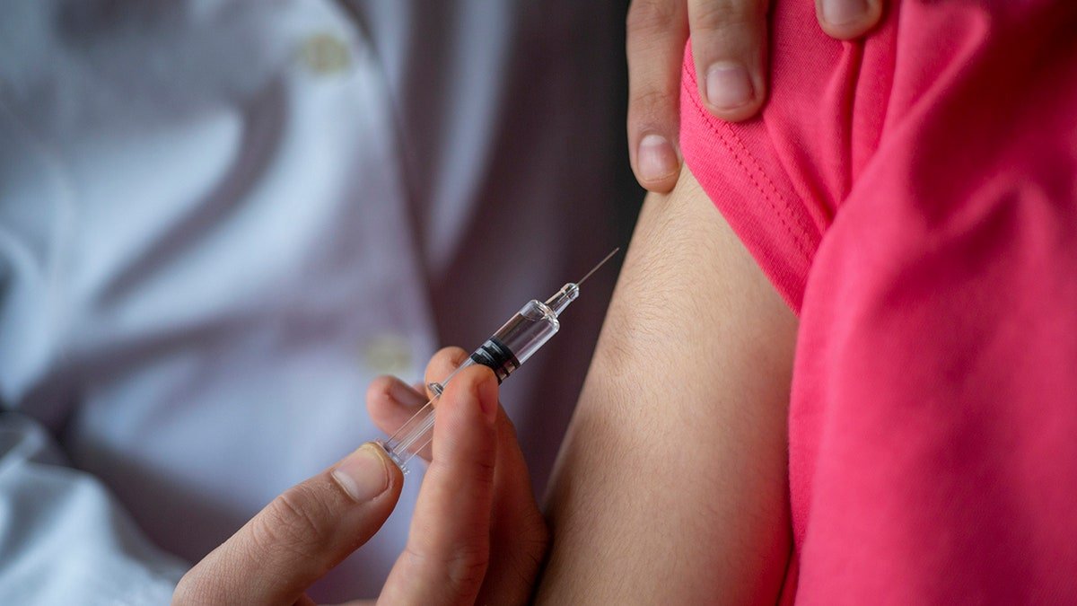 Le docteur donne une injection à un enfant